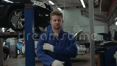 一位汽车修理工在修车厂工作时的画像，一个微笑的人在工厂仓库里